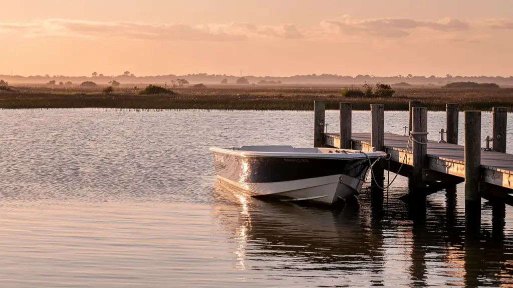 A small motorboat moored at a Gulf Coast jetty at golden hour